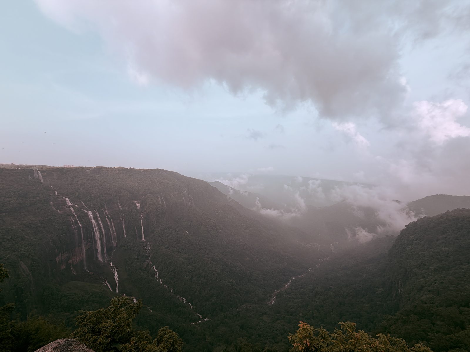 Clouds pouring over a green valley